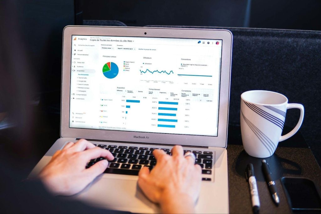 Person reviewing website analytics and campaign performance with a digital marketing dashboard on a laptop.